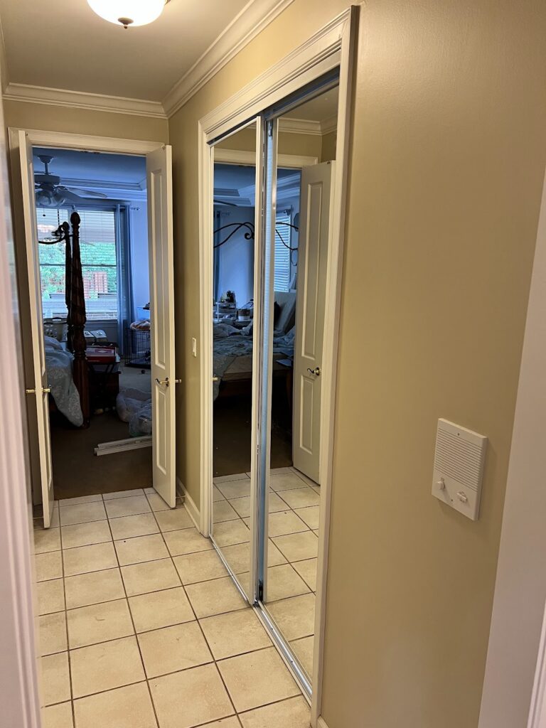 Hallway with mirrored closet doors and tile floor