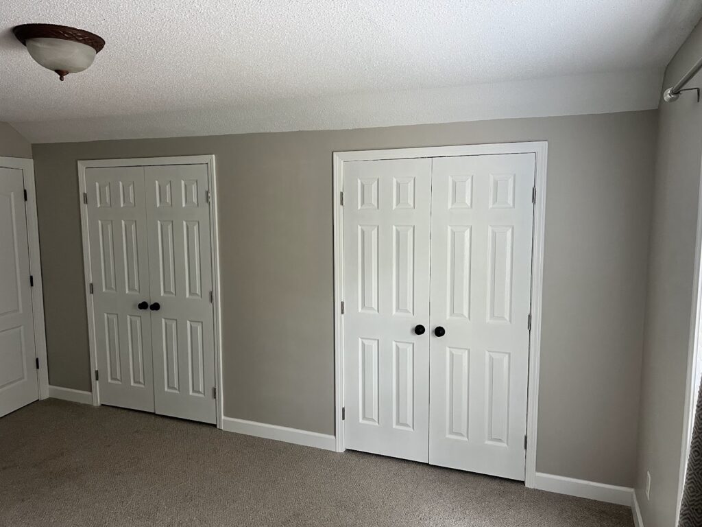 Bedroom painted gray with white closet doors